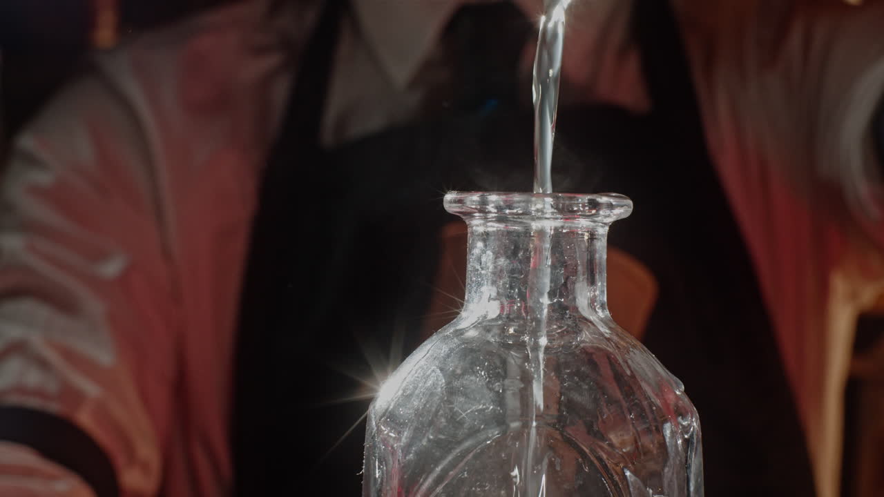Bartender pouring water into a bottle