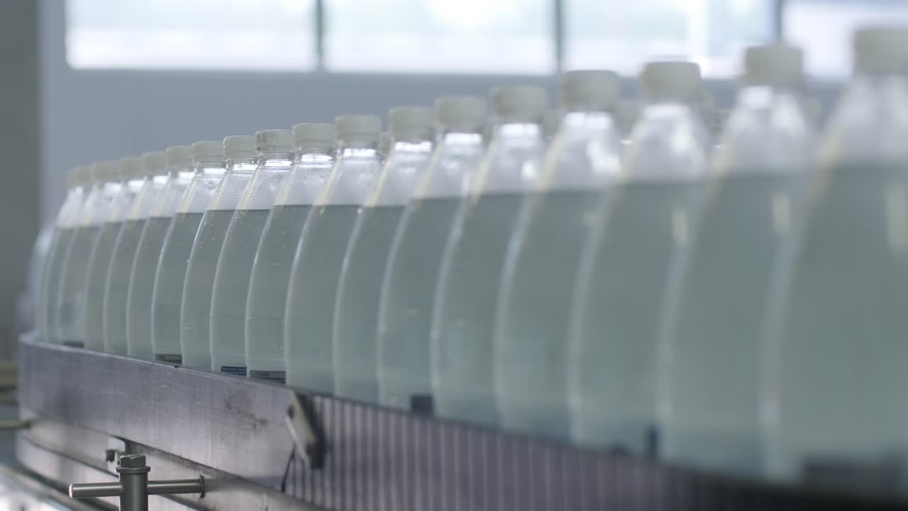 cinta transportadora con botellas de agua potable en una planta de bebidas moderna