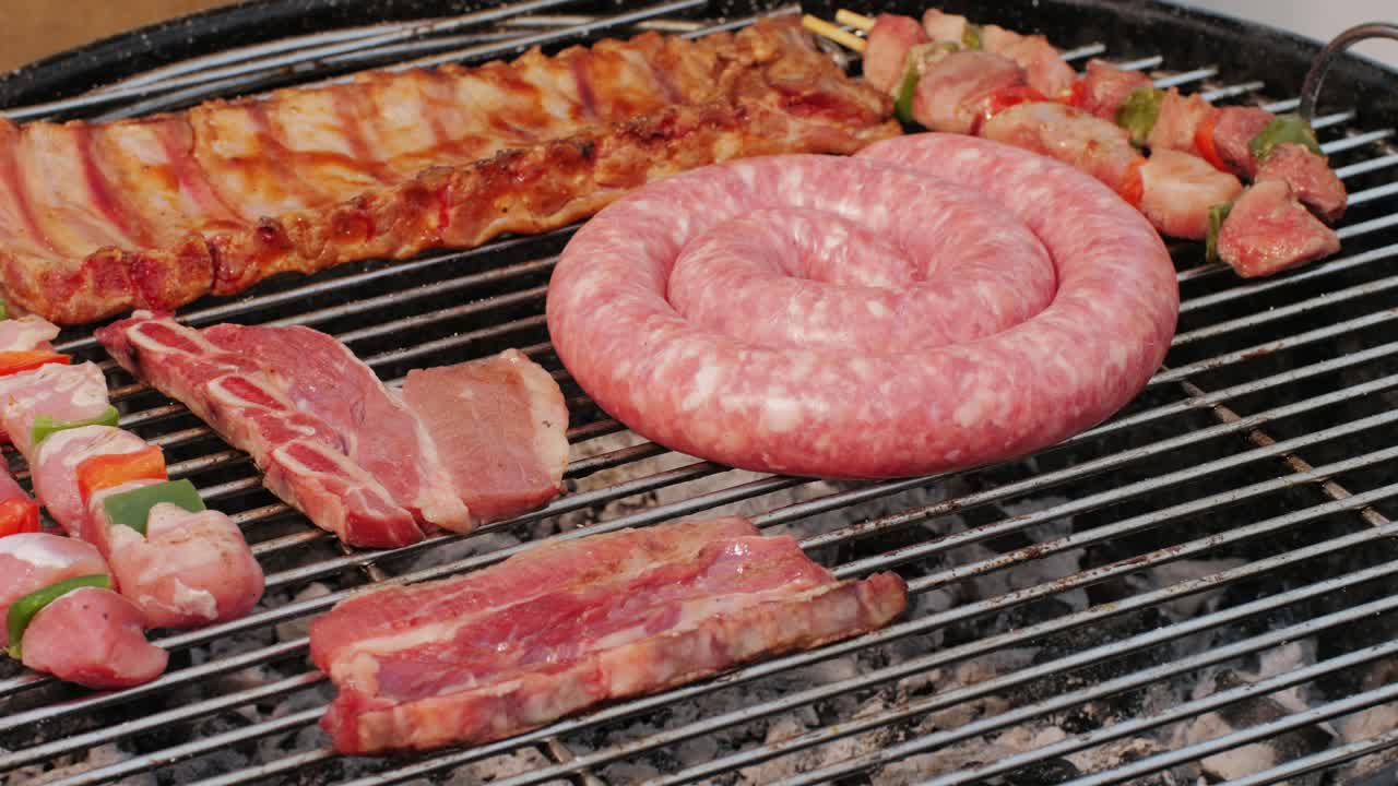 Traditional spanish barbeque, big sausage chorizo botifarra, pork and beef ribs on grill with fire, american style cooking, chef grilling meat fat food, steaks and sausages on bbq. High quality 4k footage