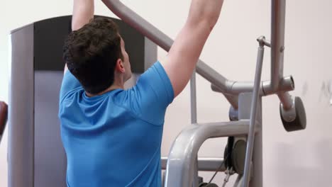 man using weights machine in gym