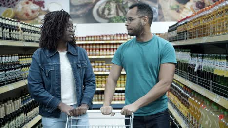 una pareja afroamericana seria hablando mientras compran.