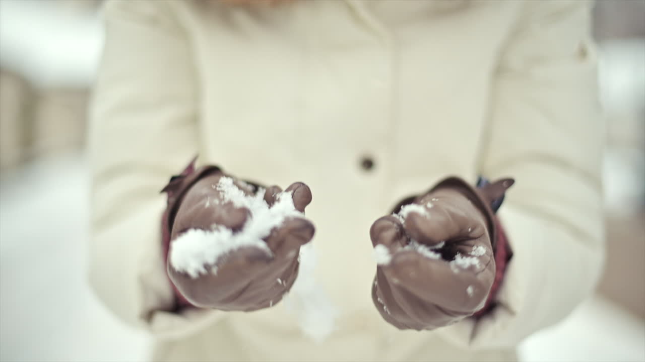 Joyful moments unfold as hands gather soft snow to make snowballs. Friends laugh and play in a beautiful winter wonderland, surrounded by fresh snow and trees