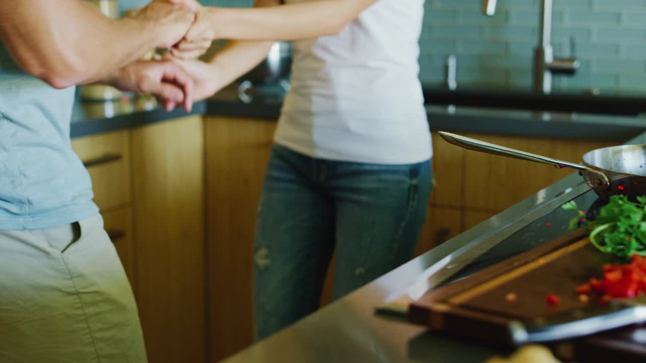 pareja cocinando y bailando en la cocina