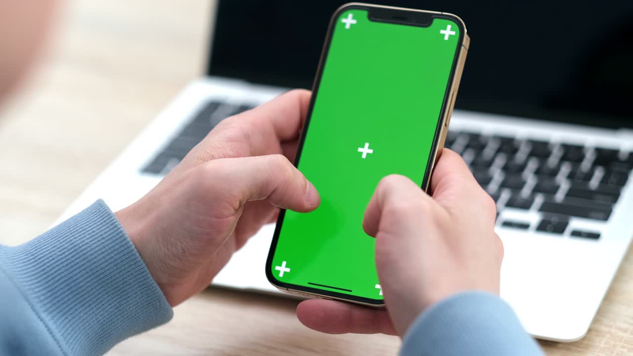 hombre usando un teléfono inteligente iphone 12 viendo pantalla verde en el teléfono presionando la tecla chroma en línea escribiendo texto leyendo redes sociales de cerca manos 24.04.21 san petrosburgo rusia