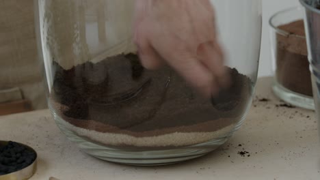 젊은 여성 식물학자는 유리 테라리움에 작은 살아있는 숲 생태계를 만듭니다.