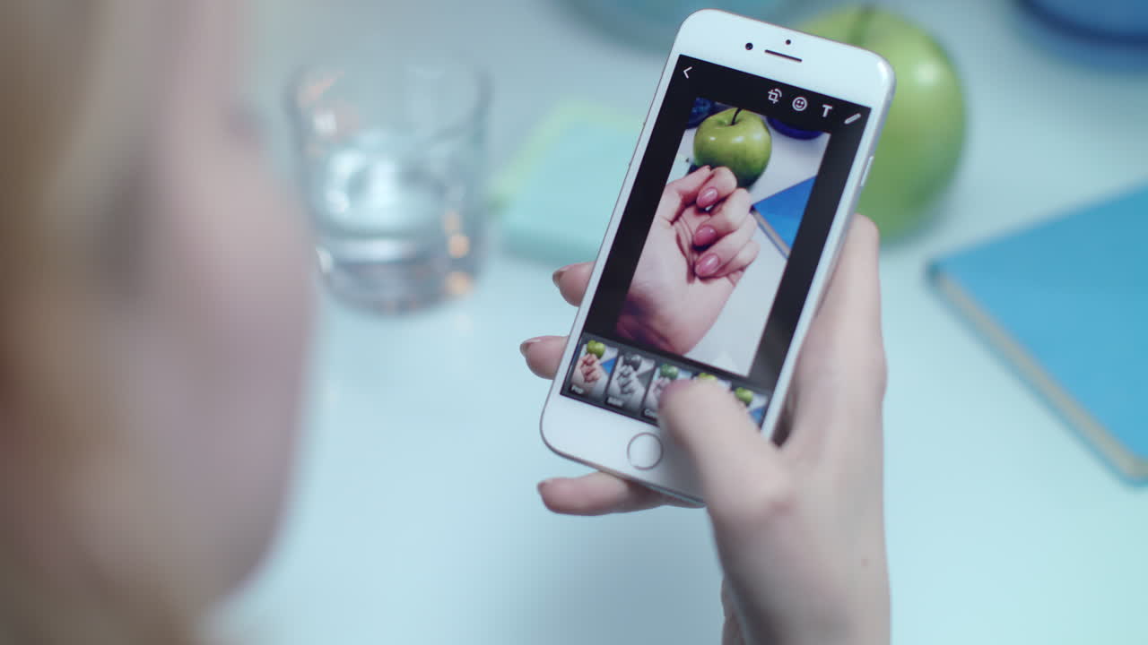 mujer chequea el filtro móvil para la foto de instagram. foto de las manos de instagram