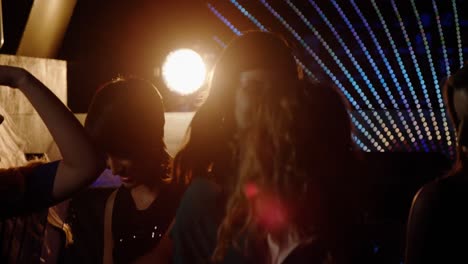 group of smiling friends dancing on dance floor