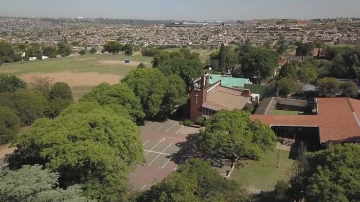 Ripresa con drone in orbita attorno a una cappella a Johannesburg, in Sudafrica, con il quartiere di River Park sullo sfondo