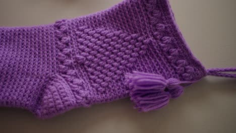 light purple handmade crochet christmas stocking on wall