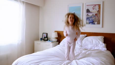 chica jugando en la cama en el dormitorio