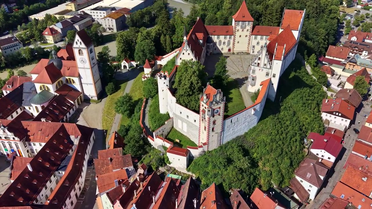 Vista aerea con drone del castello Hohes Schloss, del suo cortile e dei tetti rossi del centro storico, Fussen, Germania
