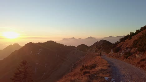 Alguien-Está-Caminando-Por-Un-Hermoso-Sendero-De-Montaña,-El-Sol-Se-Está-Poniendo,-Los-Colores-Son-Cálidos