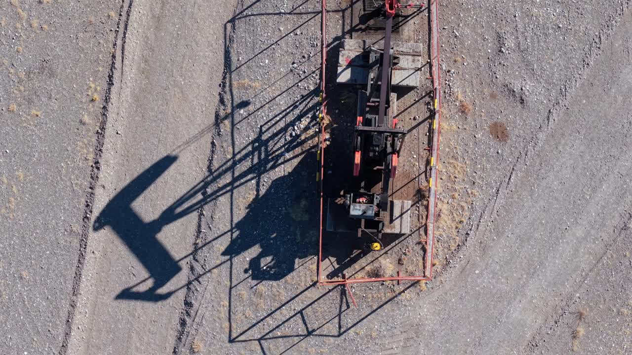 Aerial tops down Oil Pump machinery in arid landscape of Vaca Muerta, Argentina