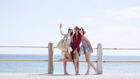 teenage girls taking selfie at beach on summer vacation centre frame composition wide shot