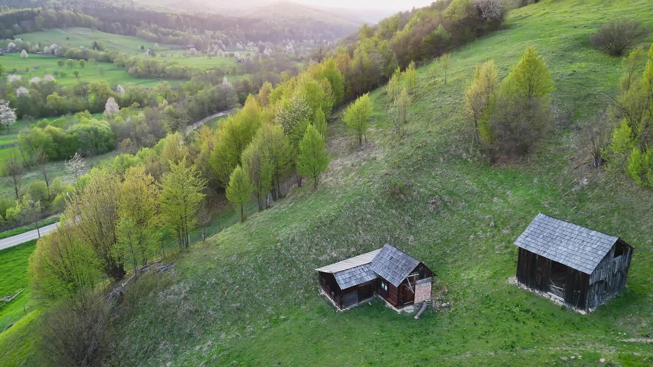Green hills and wooden structures during sunset