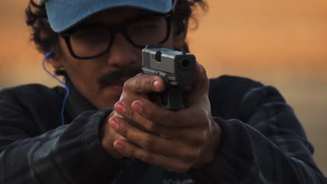 american man aiming gun at desert shooting range, ready to fire