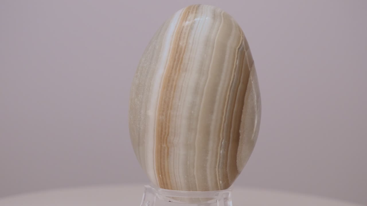 밝은 색의 오닉스 미네랄 달이 회전 테이블에서 천천히 회전합니다.