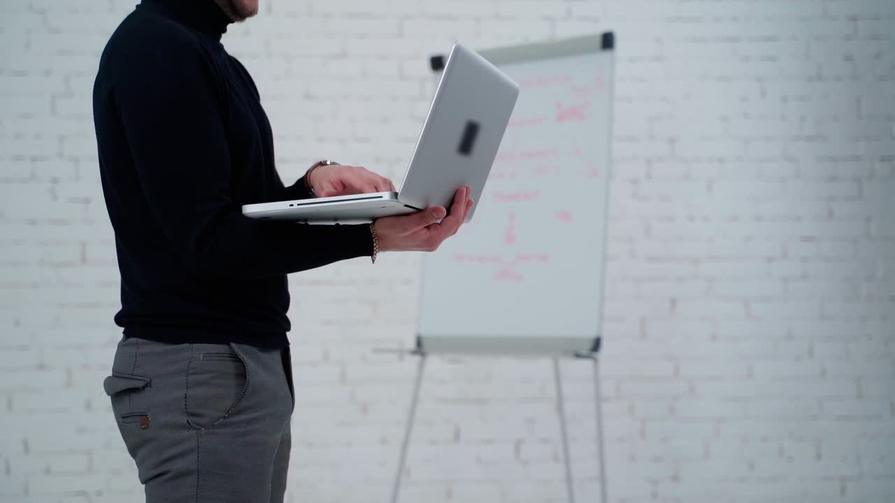 Businessman working with laptop. Close up view of standing man working on laptop