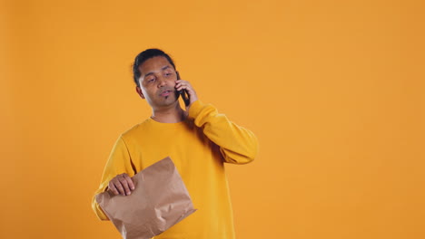 food delivery service employee talking with customer on phone, studio background