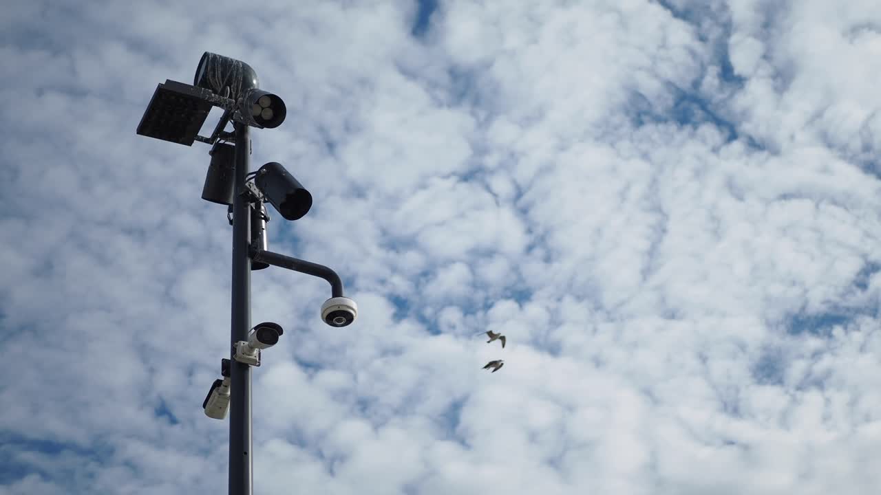 cámaras de seguridad en un poste contra un cielo nublado
