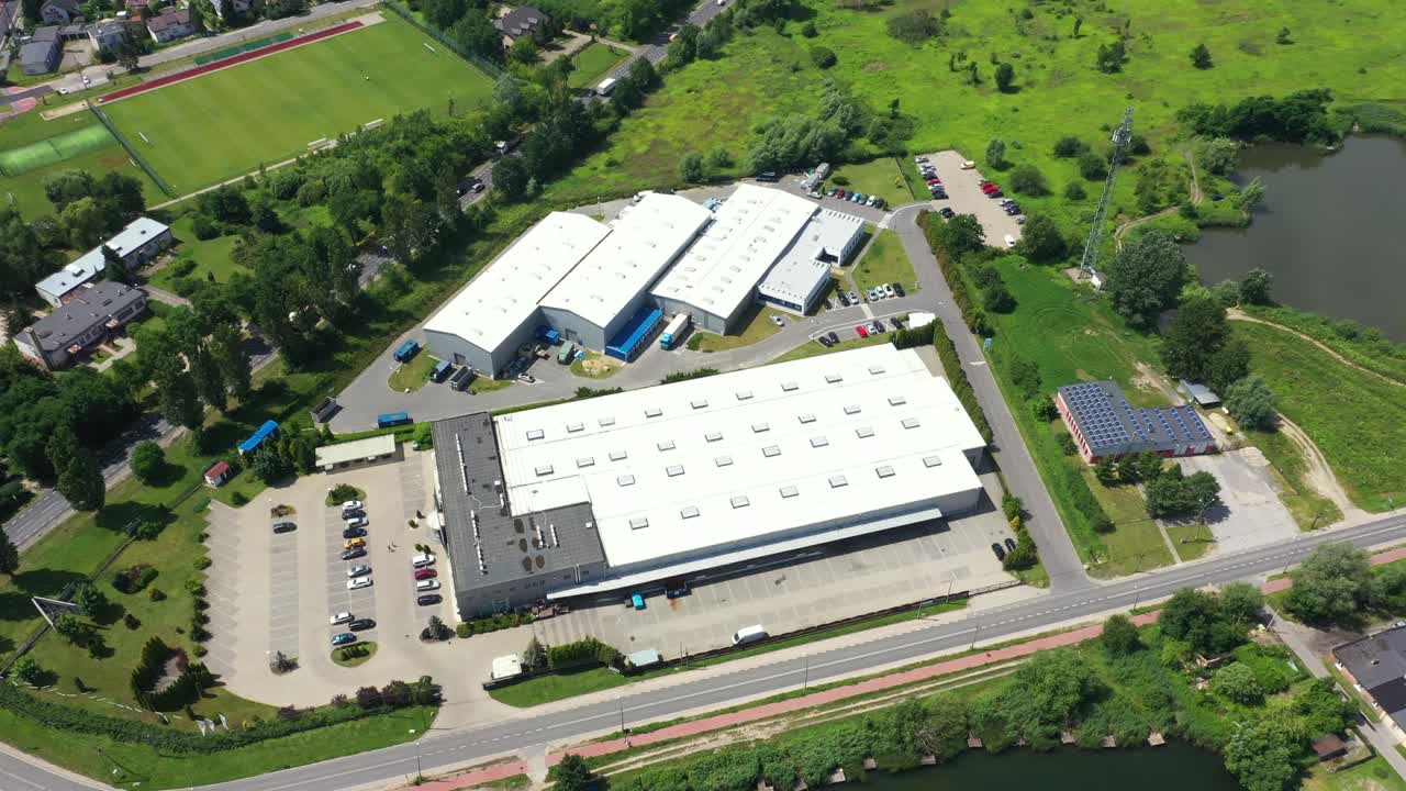 toma lateral aérea en movimiento del muelle de carga del almacén industrial donde muchos camiones con semirremolques cargan y descargan mercancías