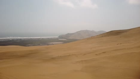 aerial - track marks on sand dunes in the ica desert, peru, wide shot truck left