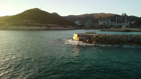 Costa-garraf-coastline-with-cement-factory-in-barcelona-at-sunset,-aerial-view