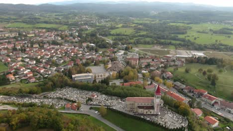 a drone shot of a cemetery on top of the hill over a city