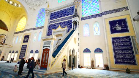 inside a beautiful mosque with people praying