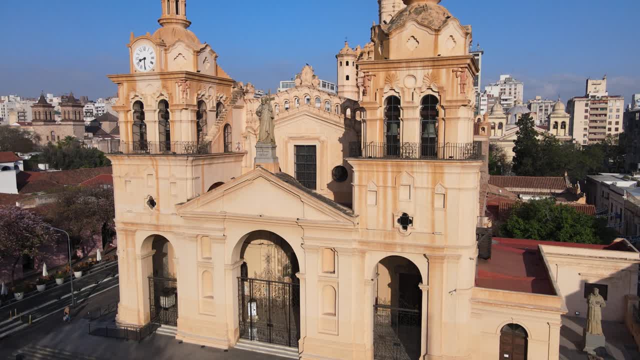 toma aérea inclinada hacia arriba, dron volando hacia la catedral de córdoba en la plaza san martín, capturando los detalles exteriores de cerca de la arquitectura histórica de estilo barroco