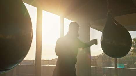 boxer, fitness and man boxing with punching bag