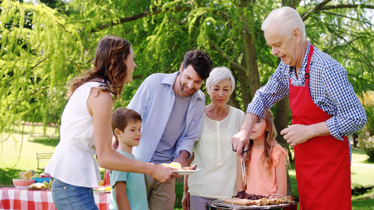 여러 세대의 가족들이 공원에서 점심을 먹고 있습니다.