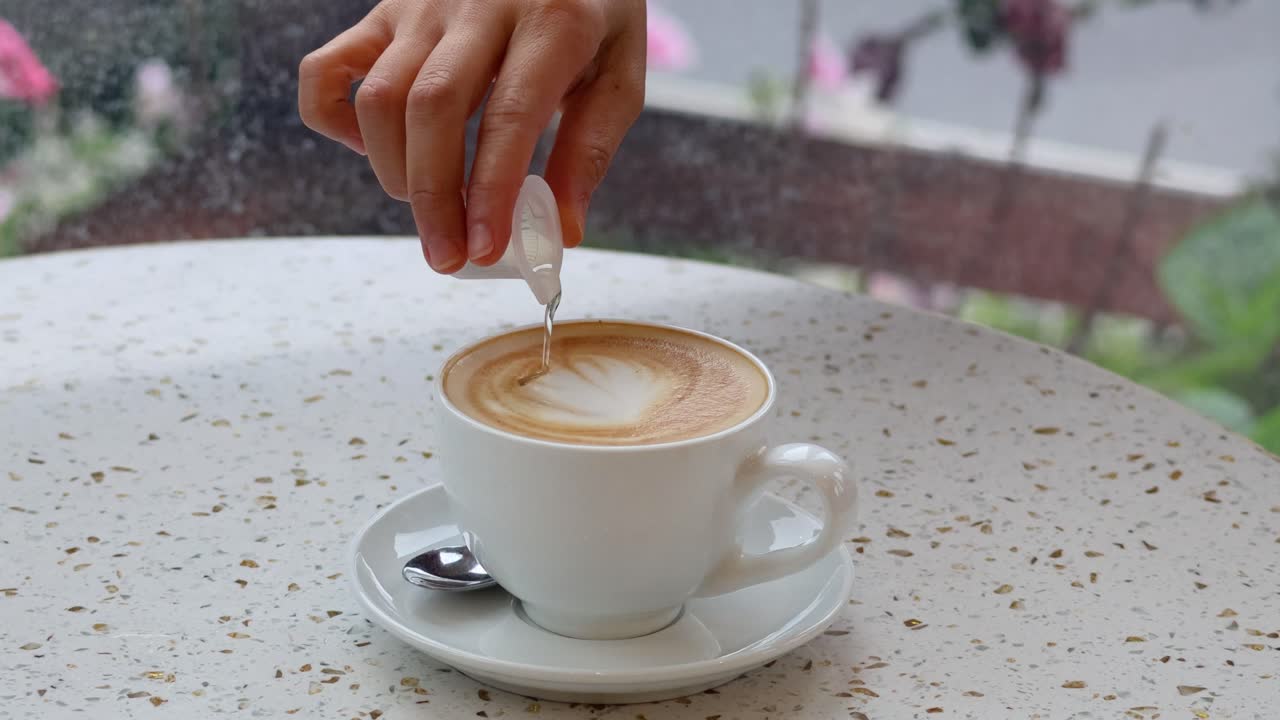 Hand adding syrup to a latte