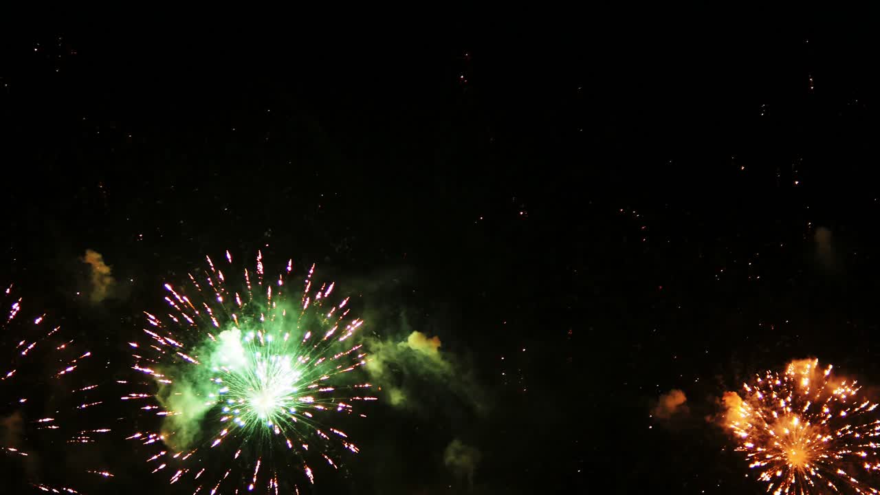 밤하늘의 보케(bokeh) 불빛으로 빛나는 황금빛의 추상적인 흐릿함과 함께 새해 전야에 아름다운 화려한 불꽃놀이가 계속됩니다.