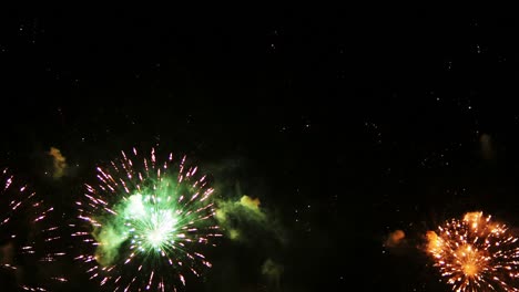 hermosos y coloridos fuegos artificiales reales continúan la celebración en la víspera de año nuevo con un desenfoque abstracto de brillo dorado con luces bokeh en el cielo nocturno