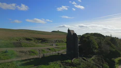 lone stone tower building on hilltop, flight to and past towards hill with structure on top