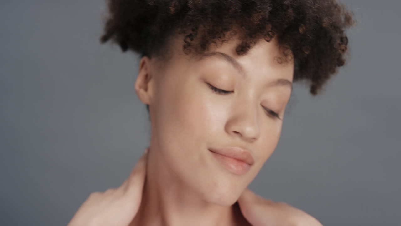 close up portrait beautiful mixed race woman touching soft skin with hand caressing smooth healthy complexion enjoying natural skincare gorgeous feminine beauty concept on grey background