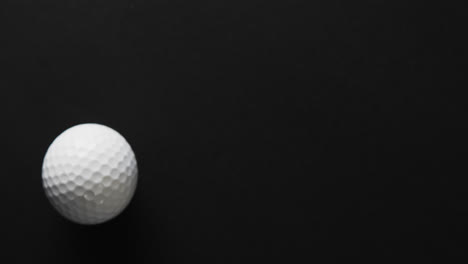 Close-up-of-golf-ball-on-black-background,-copy-space,-slow-motion