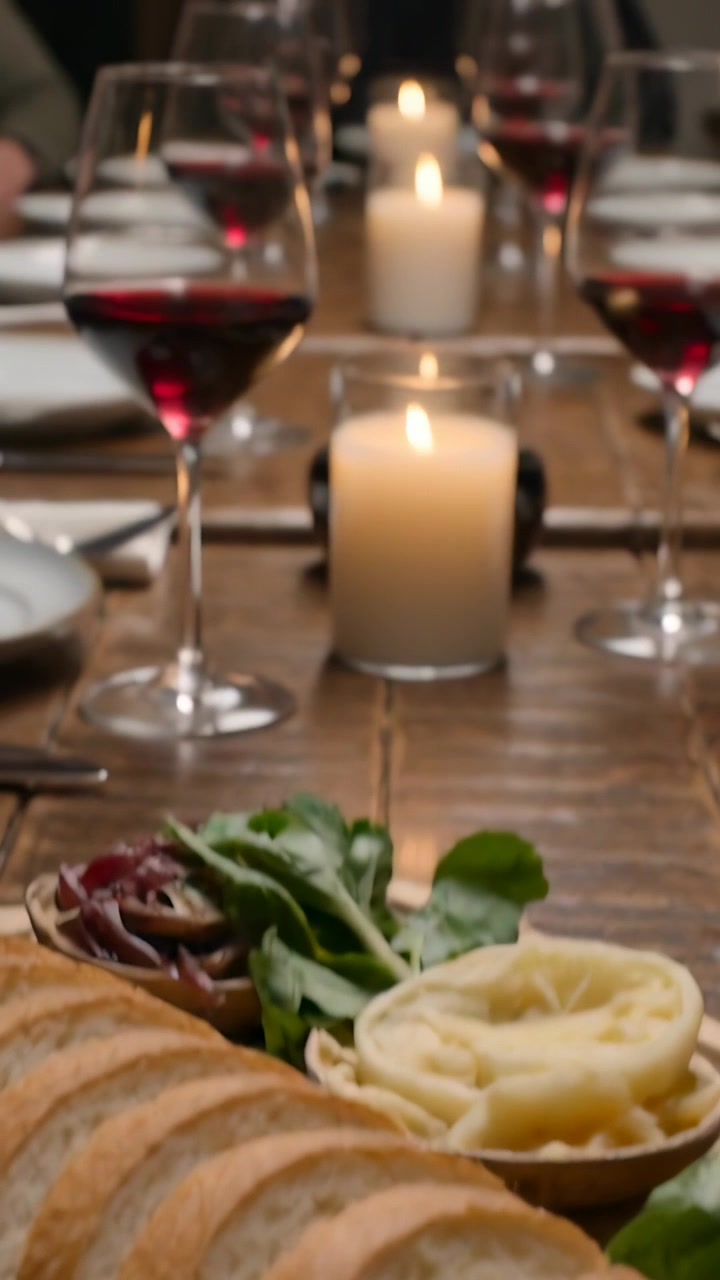 Vertical video: Pulling back camera to reveal baguette on board at home dining table with candles
