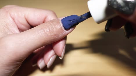 sequence of applying blue nail polish on fingernail