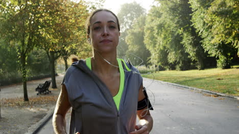 Runner-woman-running-in-park-exercising-outdoors-fitness-tracker-wearable-technology