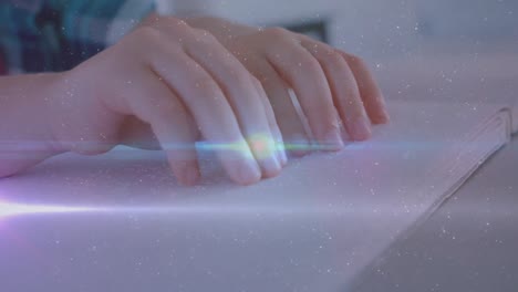 animation of light trails and spots over caucasian schoolboy reading braille