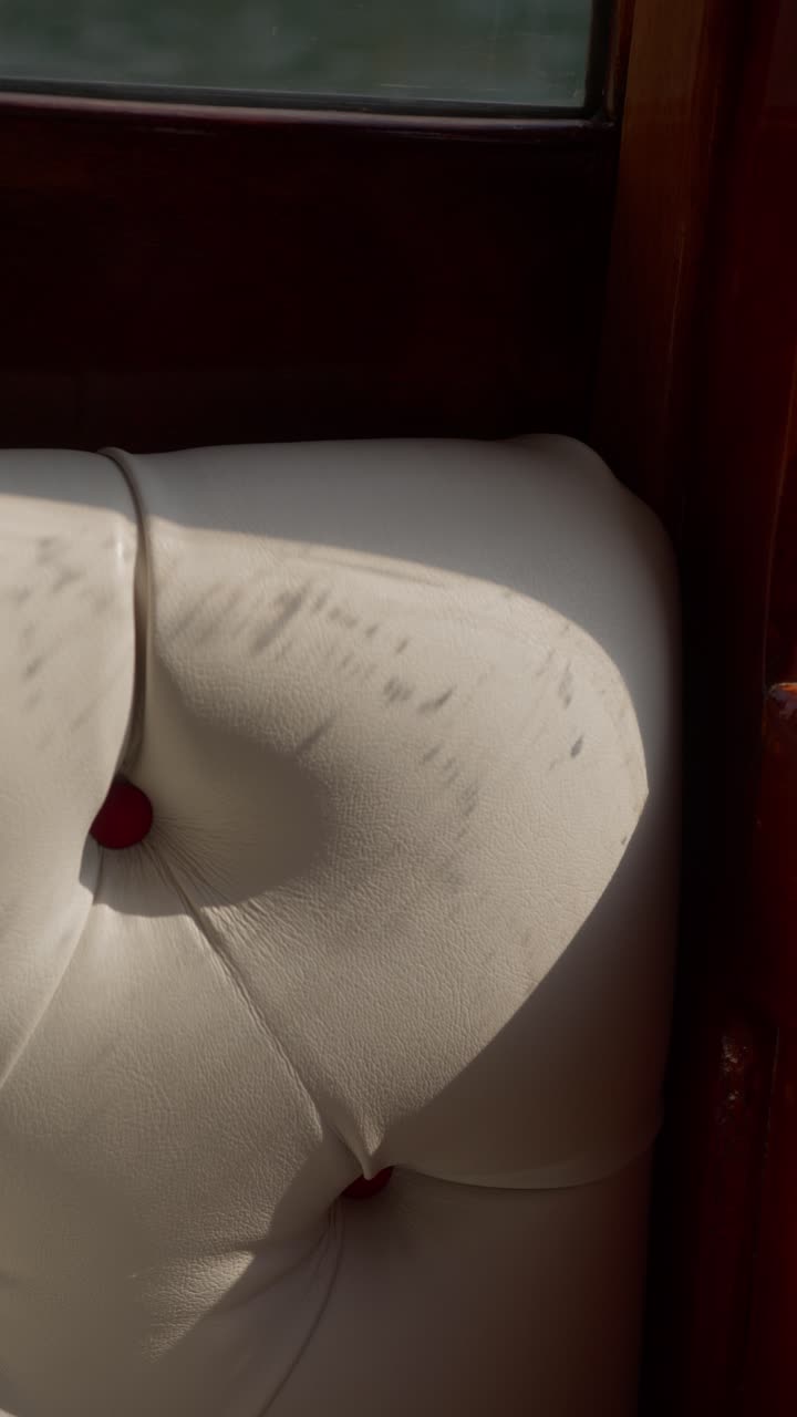 Vertical close-up of leather seat on luxury speedboat in motion at Lake Como, Italy (Lago di Como, Italia) with striking light and shadows