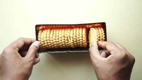 hand taking cookies out of box