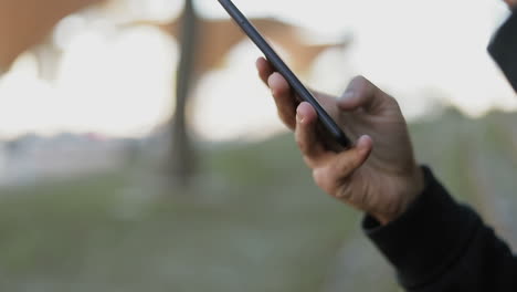 Closeup-of-young-mans-texting-on-phone