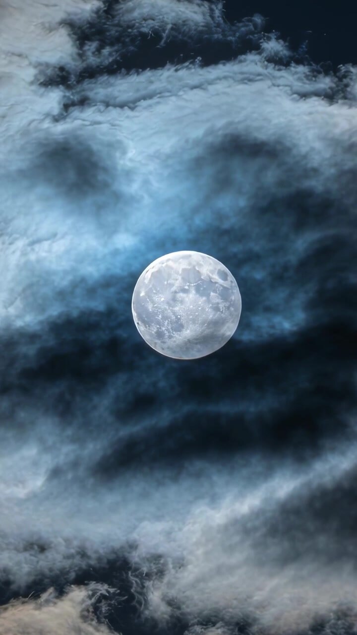 Vertikales Video: Ein leuchtender Vollmond enthüllt und verbirgt Ränder am Nachthimmel, während Wind Wolkenschichten bewegt.