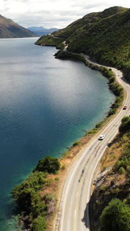 winding scenic road on lake wakatipu to queenstown. new zealand journey, road trip. vertical