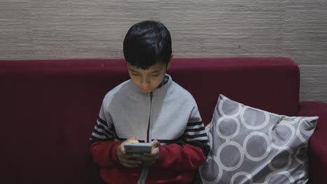 young kid watching mobile and playing online game at home caught by mother at night