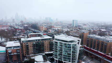 aerial drone shot of limehouse london in snow dlr train