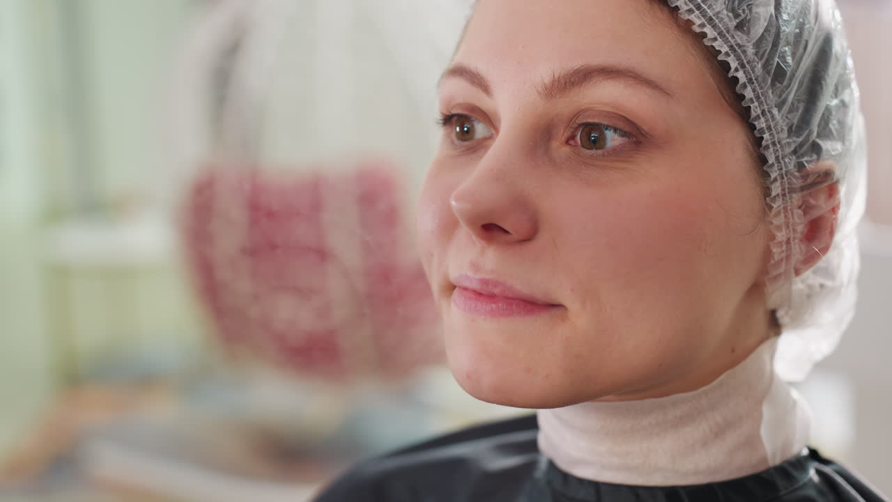 elegante retrato de salón, mujer tranquila con gorro transparente, clienta serena esperando que la peinen, señora relajada en un salón de belleza con una sonrisa amable y un gorro transparente